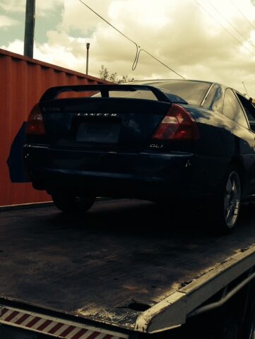 Car removal in action. Nissan car being towed.