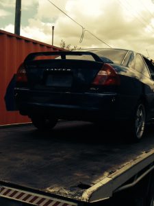 Car removal in action. Nissan car being towed.