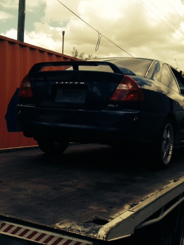 Car removal in action. Nissan car being towed.